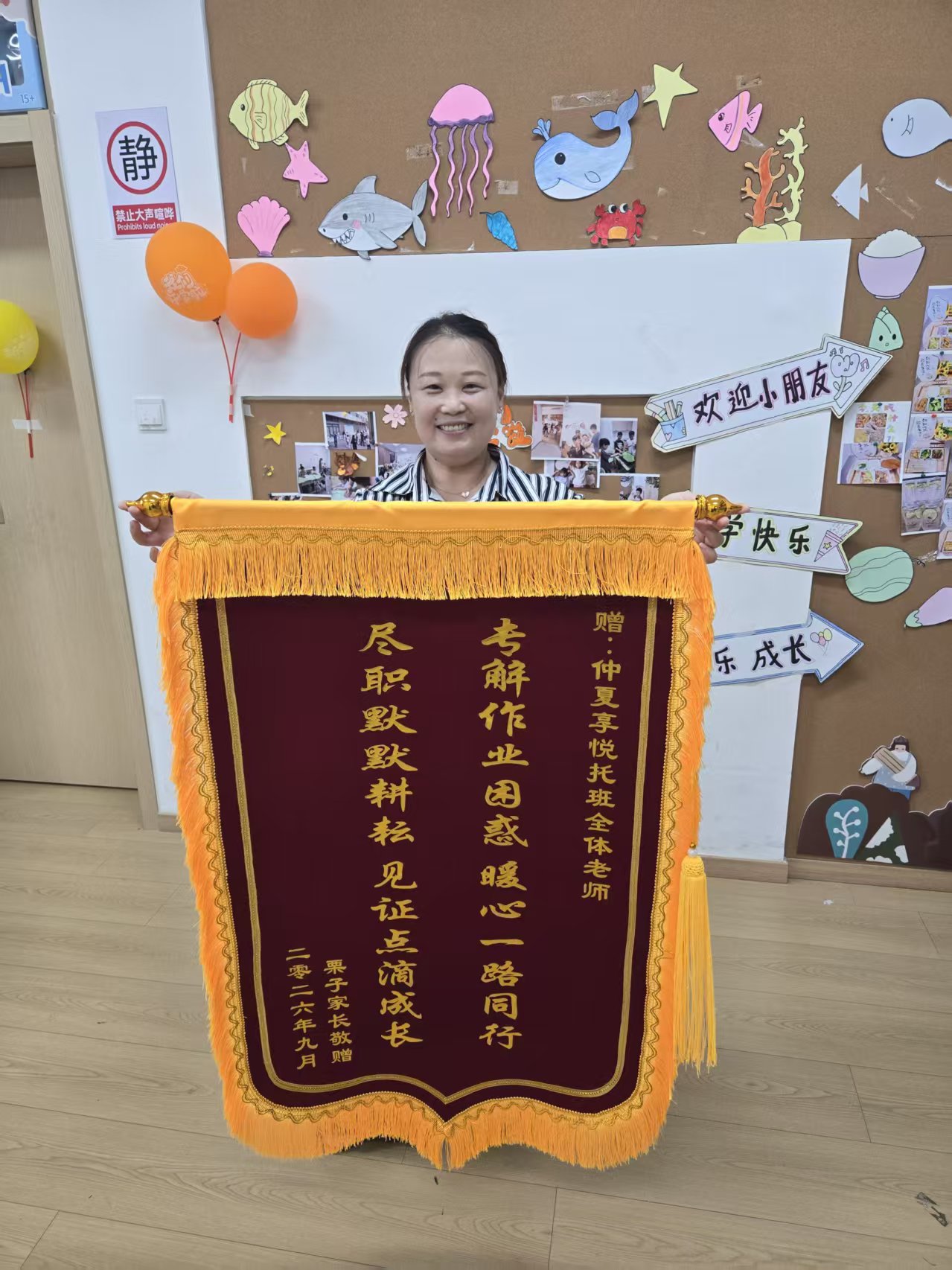 家长赠予仲夏享悦托班全体老师的锦旗,落款为2026年9月